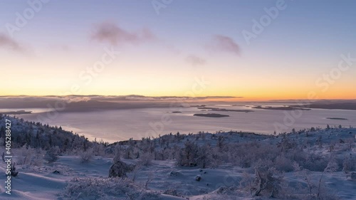 Time-lapse sunset in the mountains winter forest with lake