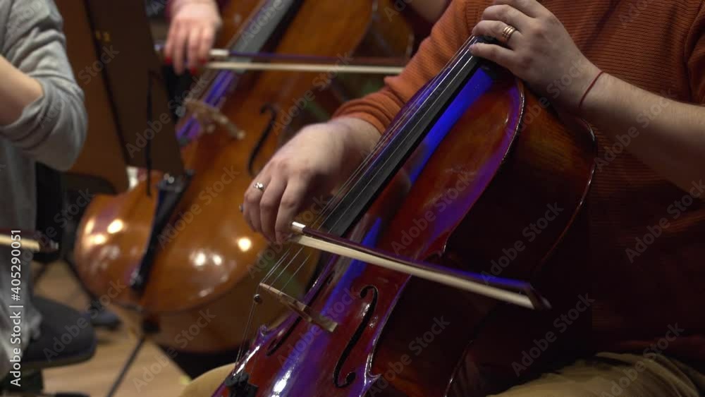 Symphony orchestra violin. Female cello player playing violoncello. Close up of woman hand playing cello. Cello player playing cello bow. Orchestra musicians instruments Symphony orchestra violin. Female cello player playing violoncello. Close up of woman hand playing cello. Cello player playing cello bow. Orchestra musicians instruments