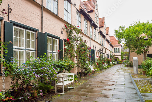 Beautiful cozy courtyard with old houses and flowers in the street of old town Lubeck  Germany