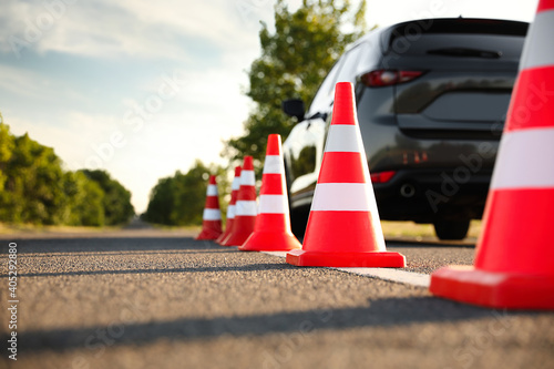 Fotografie, Obraz Traffic cones near car outdoors. Driving school exam