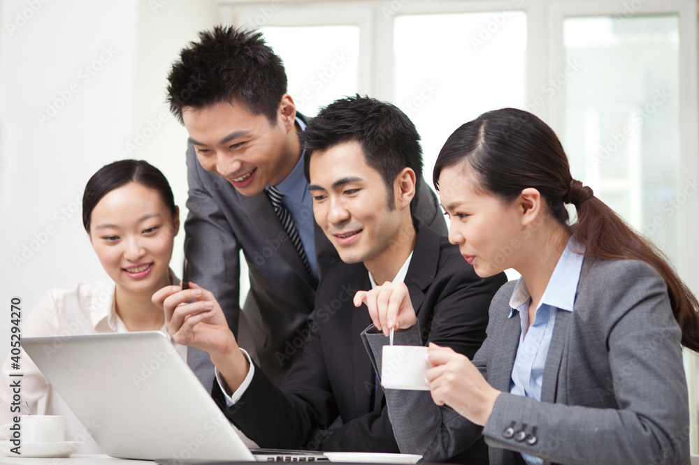 Group of businesspeople discussing working on computer Group of businesspeople discussing working on computer