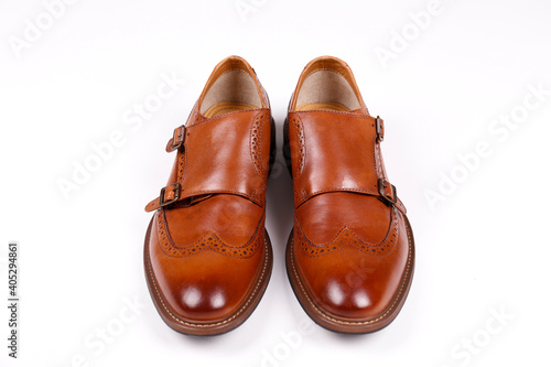 A pair of light brown double monk strap shoes isolated on white background. Versatile business casual dress shoes without laces. Top view, copy space for text, flat lay.