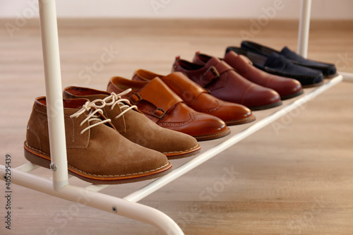 Bunch of different style men's shoes in a row. Close up shot chukka boots, single and double monk strap oxfords, brown, black and burgundy brogues. Top view, copy space, flat lay, wooden background photo