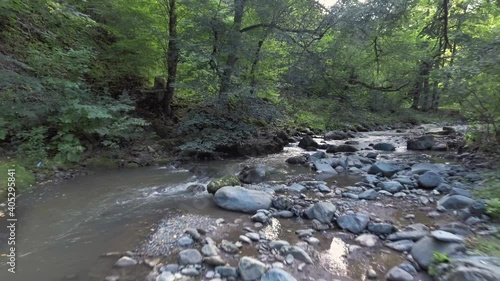 The drone flies over amountains river in forest. Aerial video. Fly Over fresh river with beautiful plants and trees. Cinematic footage. photo