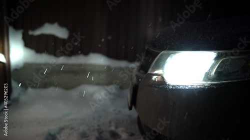 Car headlights lighting falling snow in the evening photo