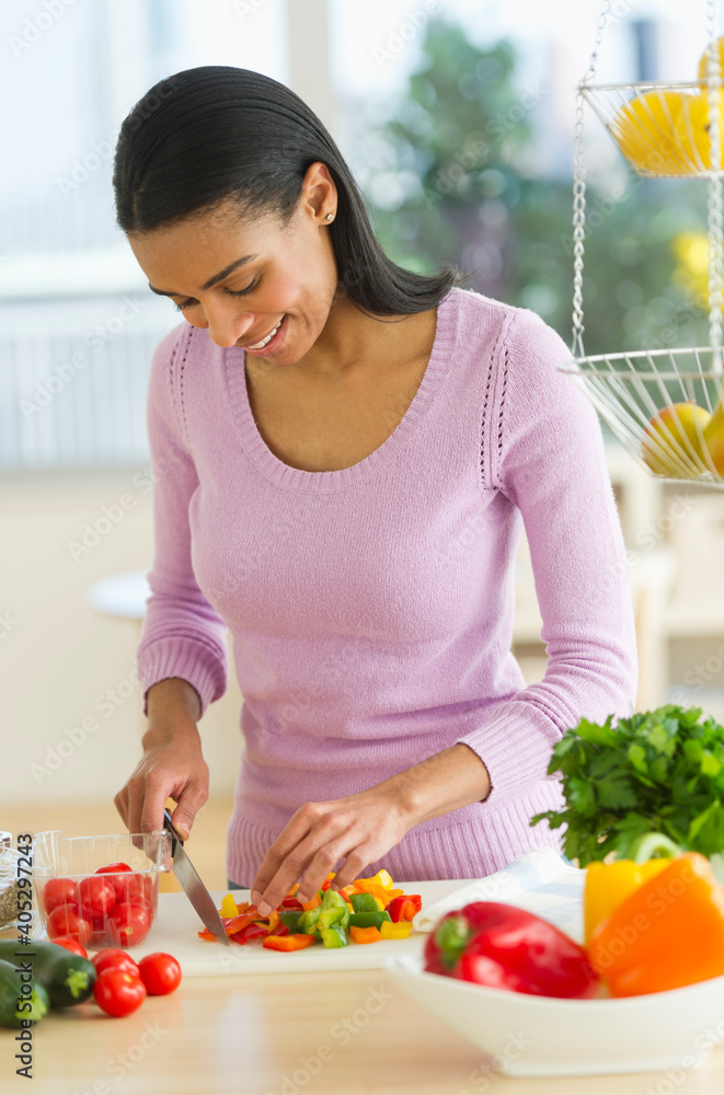 Woman chopping vegetables in kitchen Woman chopping vegetables in kitchen