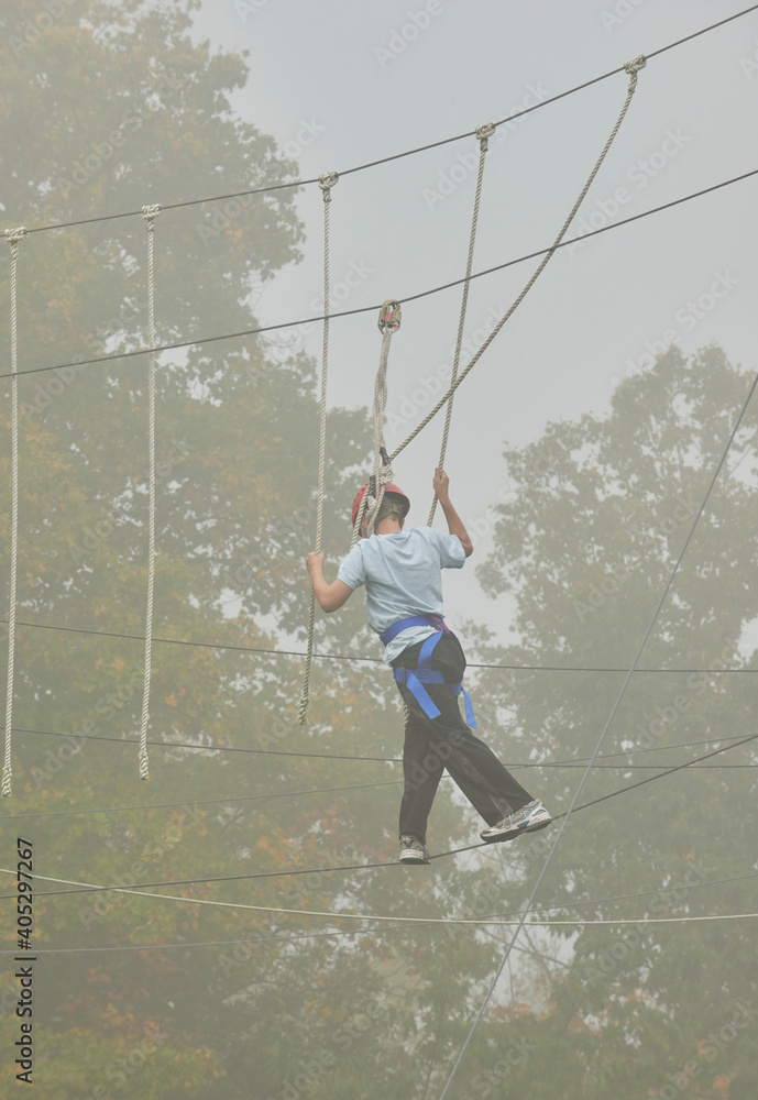 High Ropes Experience at school camp. Student crossing guide wires
