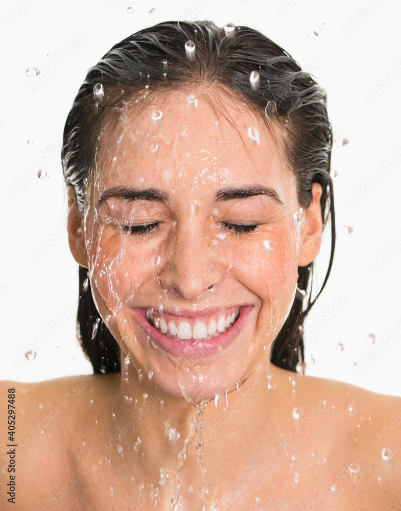 Studio shot of woman with splash of water on face Studio shot of woman with splash of water on face