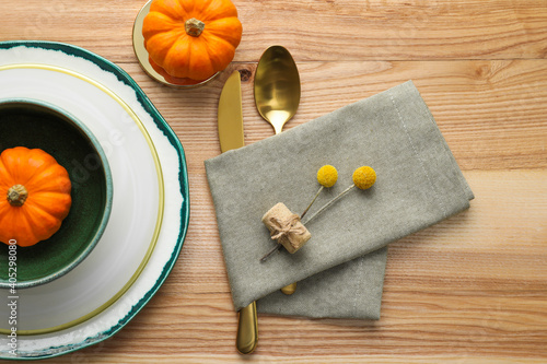 Autumn table setting with pumpkins on wooden background, flat lay
