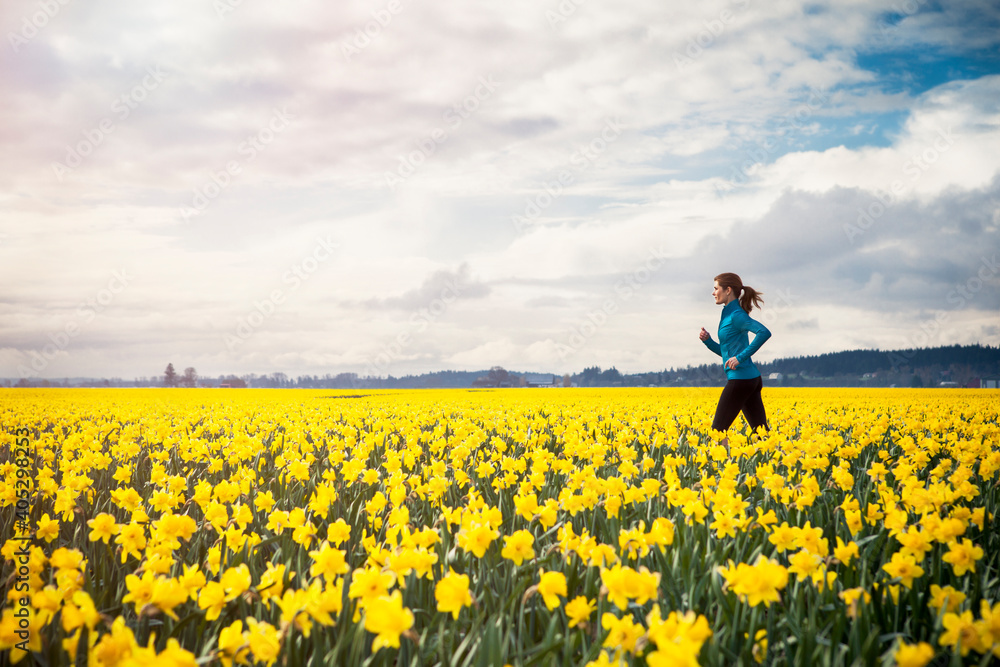 USA, Washington, Skagit Valley, Woman running through daffodil field USA, Washington, Skagit Valley, Woman running through daffodil field