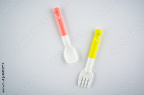 Colorful eating utensils for baby on white background