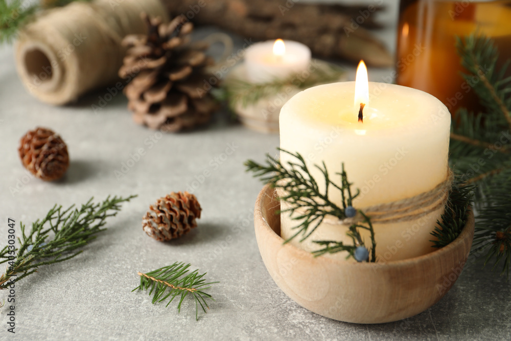 Burning candle with pinecone scent on light grey table, space for text Burning candle with pinecone scent on light grey table, space for text