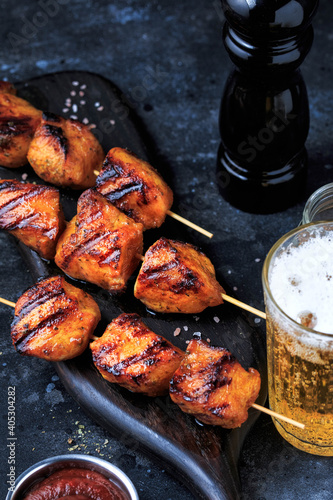 Easy and Delicious Chicken kebabs. Grilled Chicken on bamboo Skewers served with a drink. Dark Background