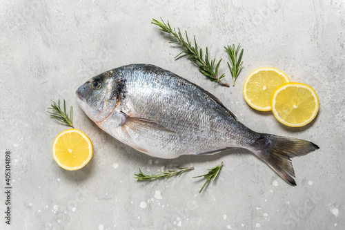 Fresh fish dorado or sea bream with ingredients for cooking  flat lay composition . Healthy food concept. Top view with copy space.