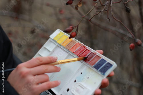 The girl's hand holds paints and imagines that she is painting nature.