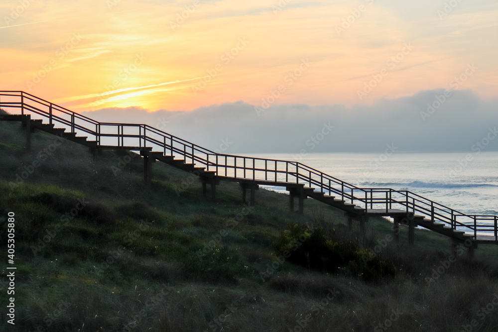 Shady silhouette of a wooden staircase from the side that leads from the ground into the sky to the sunset Shady silhouette of a wooden staircase from the side that leads from the ground into the sky to the sunset