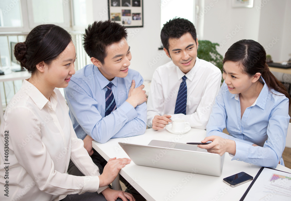 Group of businesspeople discussing working on computer Group of businesspeople discussing working on computer