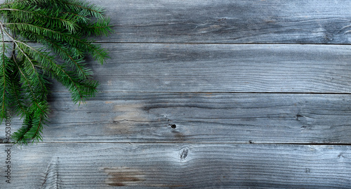 Merry Christmas background with real fir branch on natural rustic wood