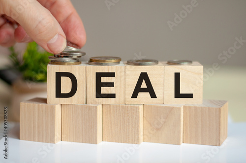 The word deal on wood cubes with file folder document background, business concept.