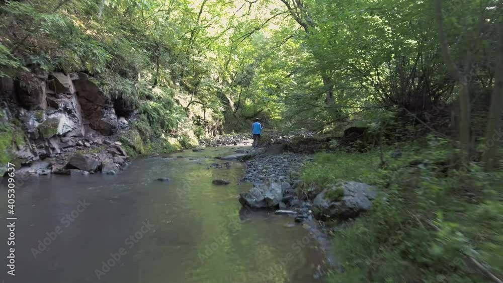 Fisherman are fishing in a mountain stream for brook trout. Fly Over River and Fishing Man. Trout fly fishing and catching. Fish Catch cinematic top view footage. High view. Fisherman are fishing in a mountain stream for brook trout. Fly Over River and Fishing Man. Trout fly fishing and catching. Fish Catch cinematic top view footage. High view.