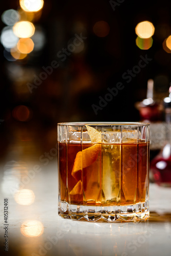 Old fashioned Negroni classic cocktail served on the rocks on counter bar background. Whisky Old Fashioned served on rocks with orange