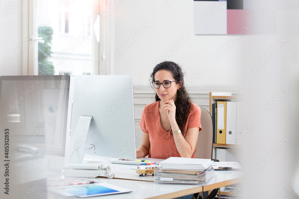 Female professional smiling while using computer in office Female professional smiling while using computer in office