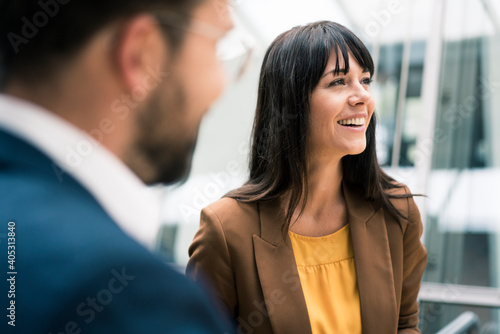Wallpaper Mural Happy female entrepreneur looking away while standing by male colleague in office Torontodigital.ca