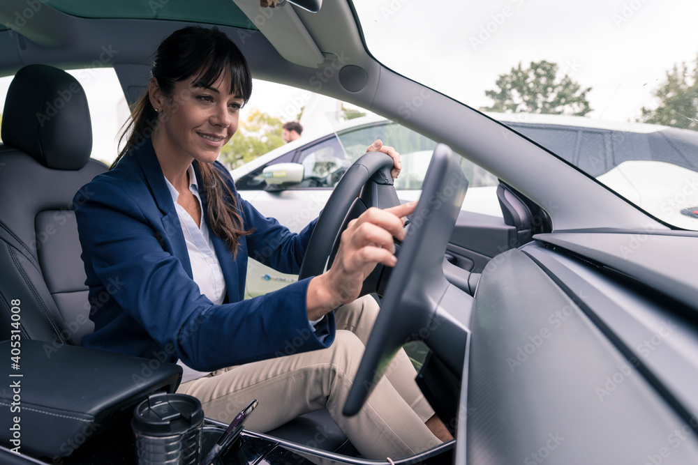 Smiling female entrepreneur navigating through device while sitting in car Smiling female entrepreneur navigating through device while sitting in car