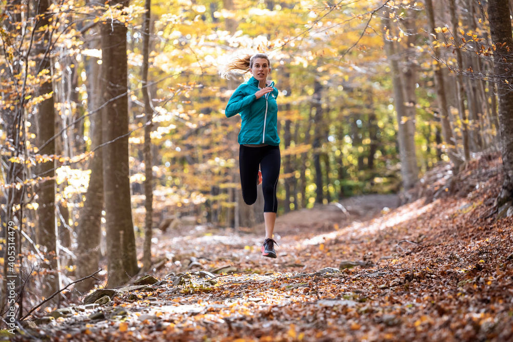 Young sportswoman running on forest path Young sportswoman running on forest path