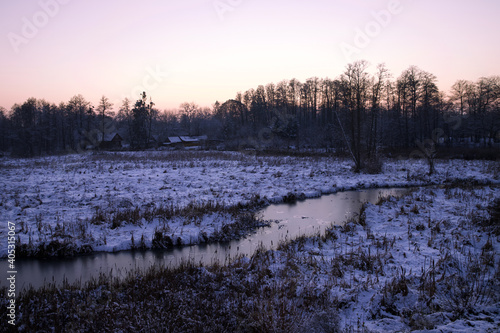 Winter landscape by the river in the evening time.
