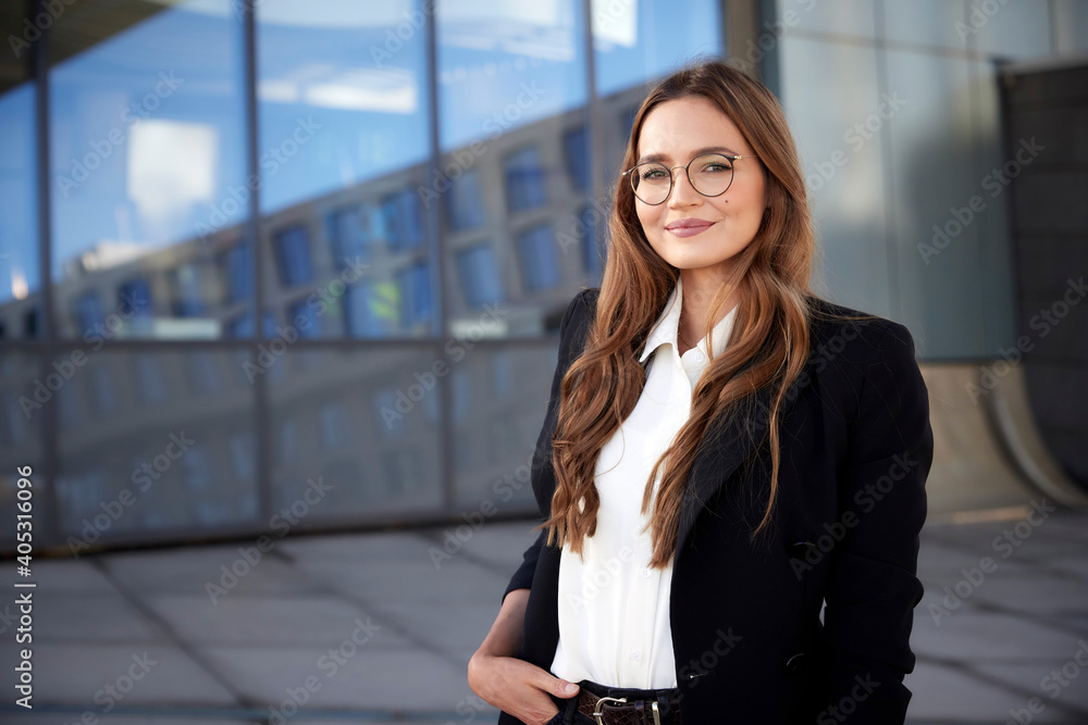 Confident businesswoman wearing eyeglasses with hand in pocket standing outdoors Confident businesswoman wearing eyeglasses with hand in pocket standing outdoors