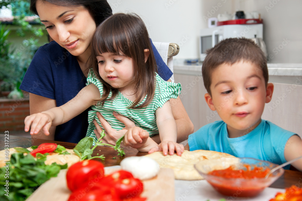 Mother with son and daughter making homemade pizza Mother with son and daughter making homemade pizza