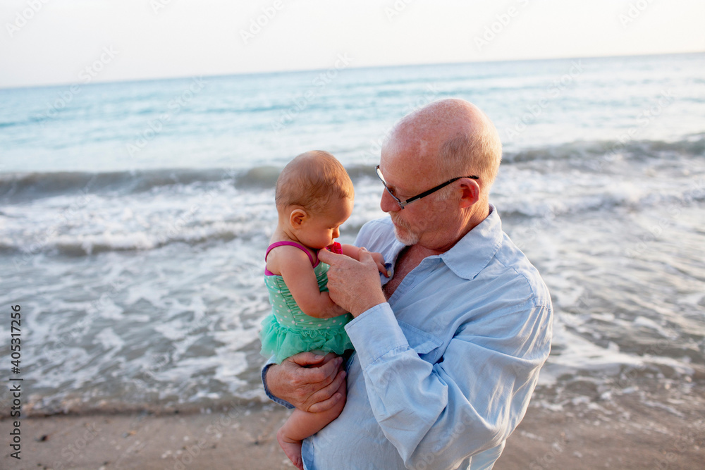 Grandfather with granddaughter on beach, St Maarten, Netherlands Grandfather with granddaughter on beach, St Maarten, Netherlands