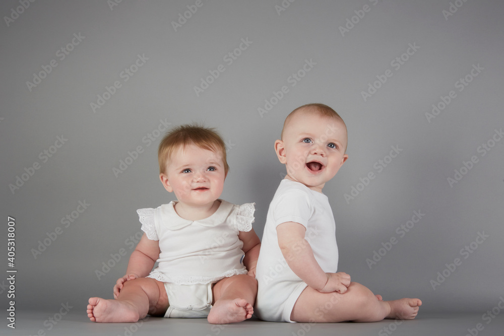 Studio portrait of smiling baby boy and baby girl Studio portrait of smiling baby boy and baby girl