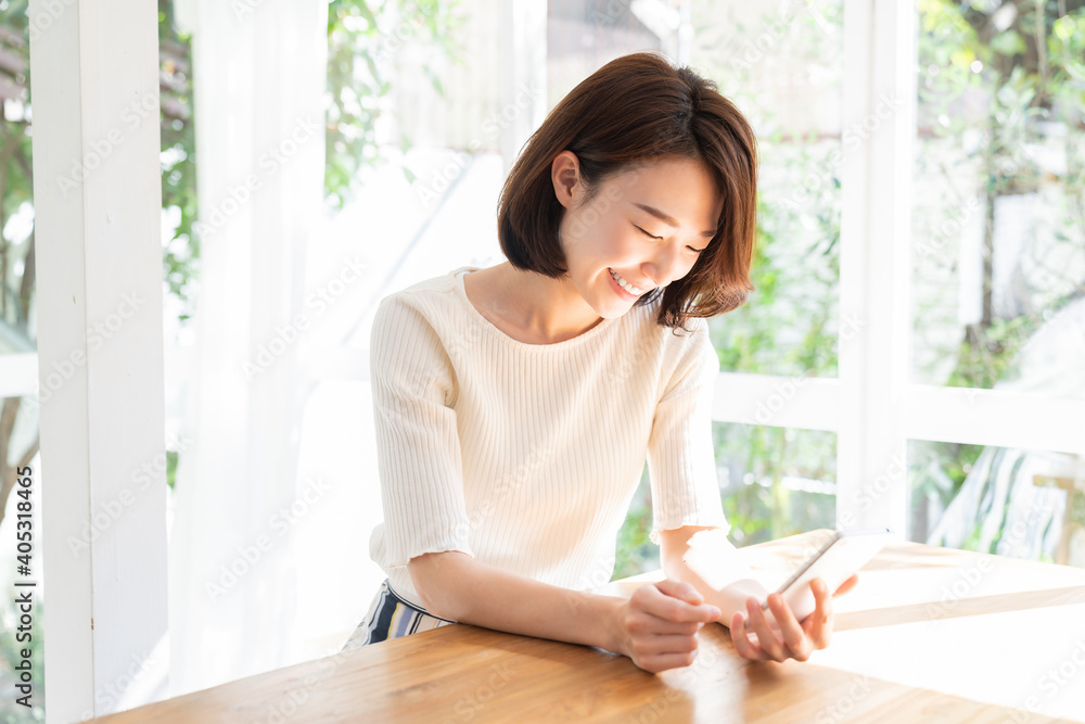 部屋でスマホを見る女性 部屋でスマホを見る女性
