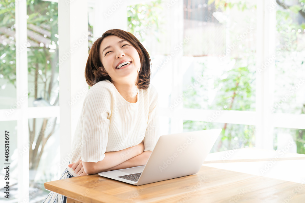 部屋でラップトップコンピューターを見る女性 部屋でラップトップコンピューターを見る女性