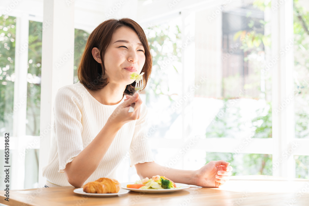 サラダとパンを食べる女性