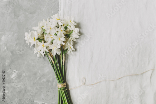 Bouquet of daffodil flowers on textured gray and white linen background. Flowers composition. Flat lay, top view, copy space. Spring, summer concept.