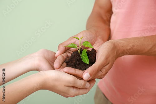 Hands of family with soil a...