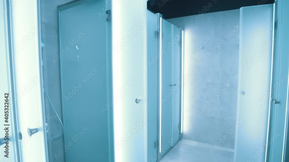 Indoor view of modern stylish commercial shower cubicles and changing rooms inside professional gym. Sports club interior. Indoor view of modern stylish commercial shower cubicles and changing rooms inside professional gym. Sports club interior.
