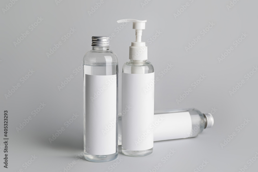 Different bottles of cosmetic products on gray background Different bottles of cosmetic products on gray background