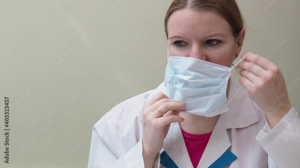 Portrait of doctor in quarantine in hospital, coronavirus concept. the doctor puts on and takes off the mask and gloves, makes a beer vaccine Portrait of doctor in quarantine in hospital, coronavirus concept. the doctor puts on and takes off the mask and gloves, makes a beer vaccine