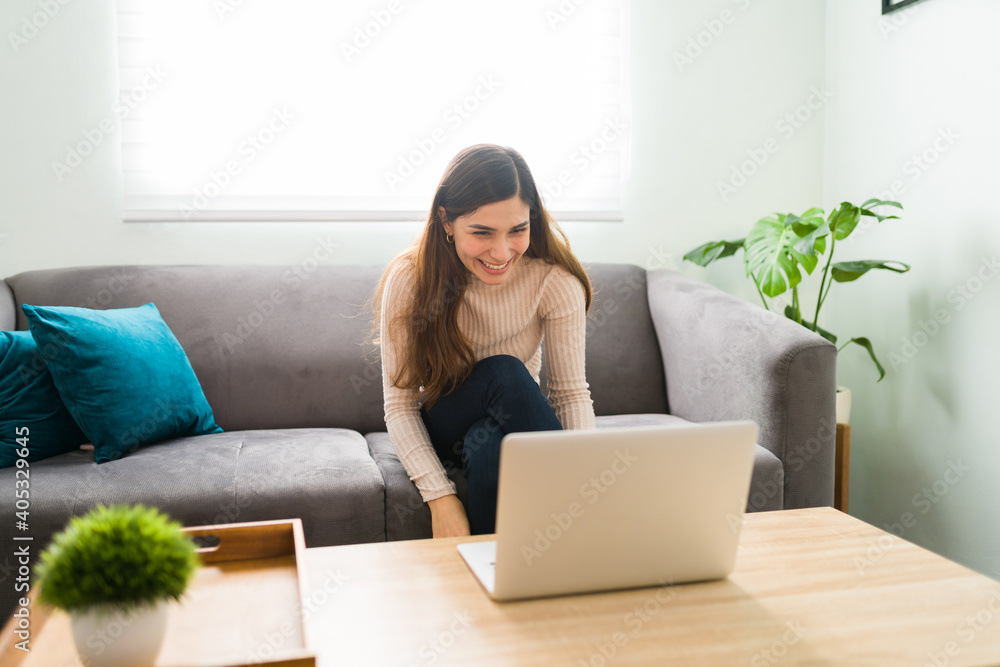 Young woman laughing with friends in a video chat Young woman laughing with friends in a video chat