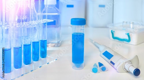 Science and molecular biology background, panoramic image. Pipette, plastic tubes for pcr analysis of dna and rna, automatic pipette and tubes with reagents and buffers.