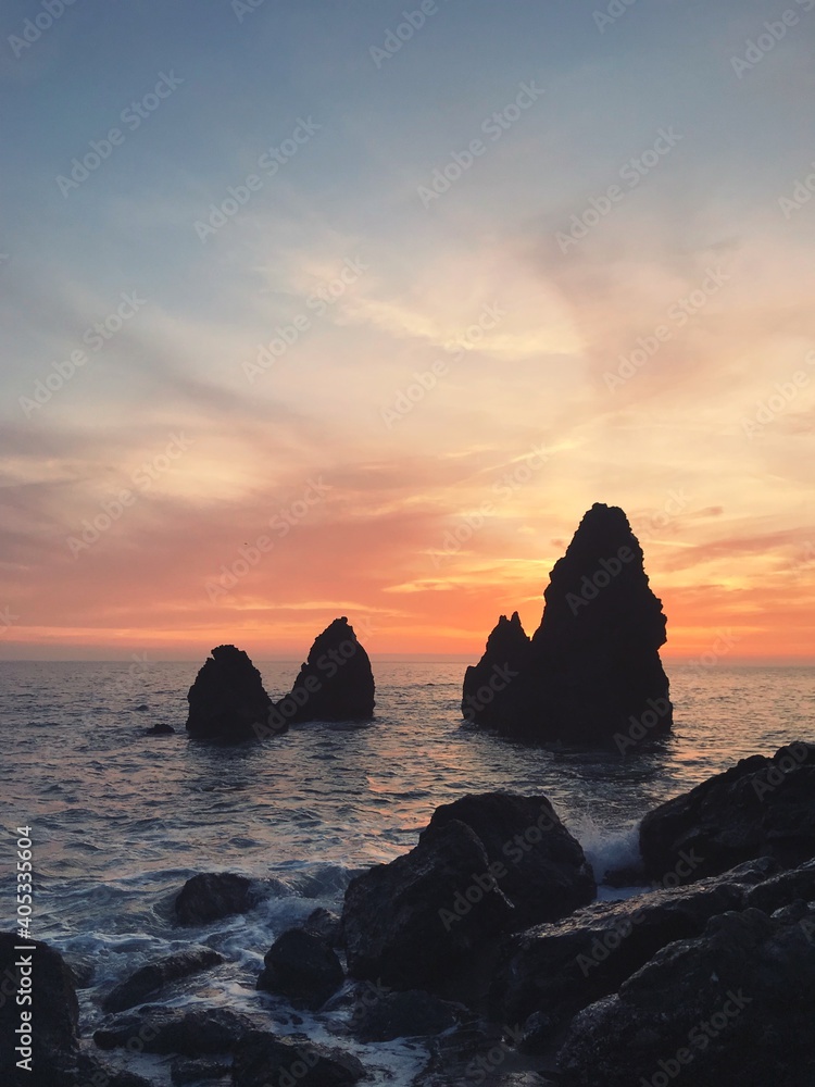 Rocks In Sea Against Sky During Sunset