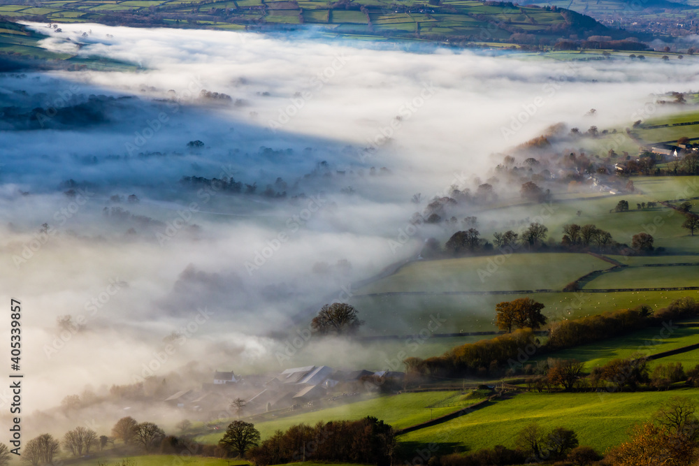 Green fields and rural farmland covered in low hanging mist and fog Green fields and rural farmland covered in low hanging mist and fog
