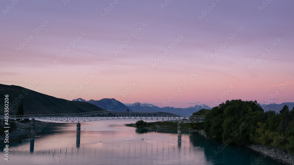 Dramatic twilight of Lake Tekapo new bridge with the snowy peaks behind. New Zealand