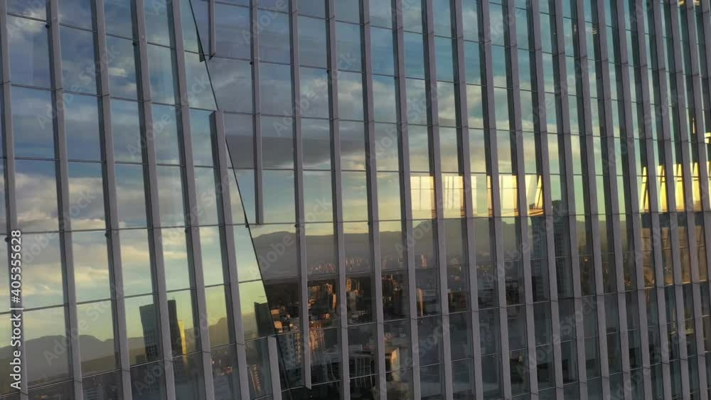 Reflection of the city through a glass facade with the transition of the sun's flare Reflection of the city through a glass facade with the transition of the sun's flare