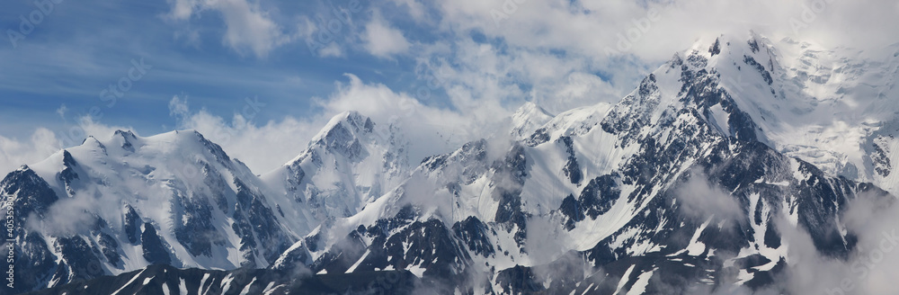 Obraz premium Snow-capped mountain peaks. Traveling in the mountains, climbing. Panoramic view.