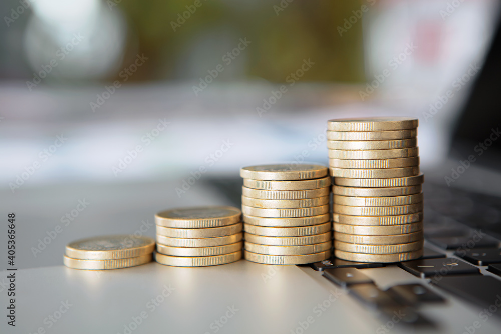 A row of increasing euro coins on a laptop keyboard A row of increasing euro coins on a laptop keyboard